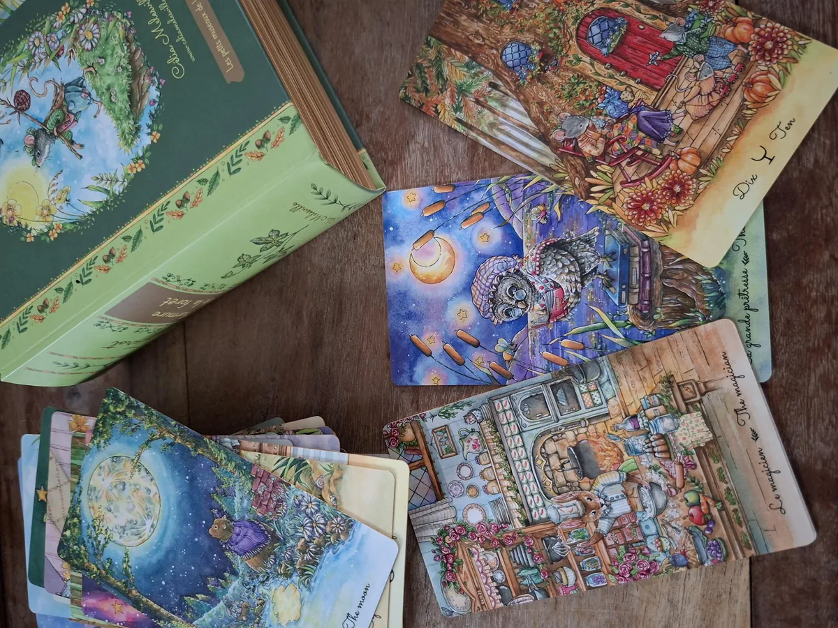 Les jeux de cartes illustrés d'Élodie, cartomancienne, étalés sur une table en bois